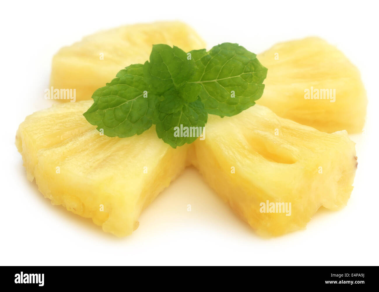 Sliced pineapple with mint leaves over whtie background Stock Photo