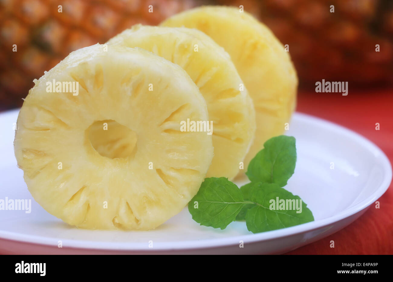Sliced pineapple with mint leaves on a plate Stock Photo