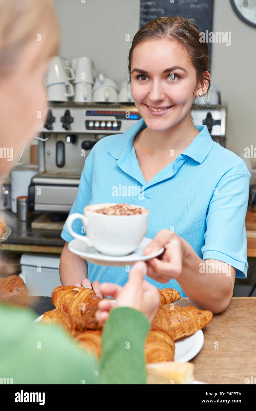 Waitress In Cafe Serving Customer With Coffee Stock Photo