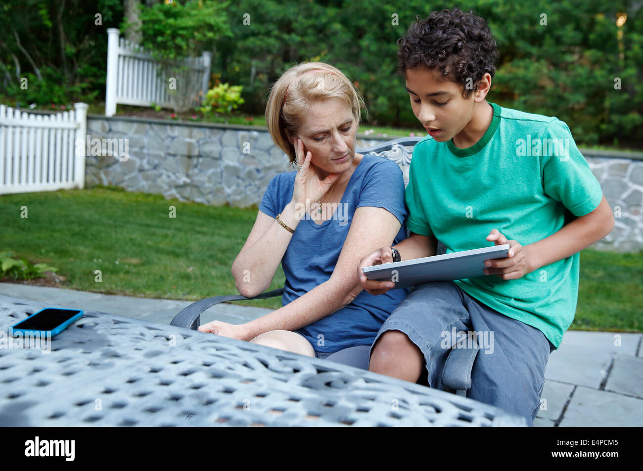 A boy shows his mother how to use a tablet computer Stock Photo