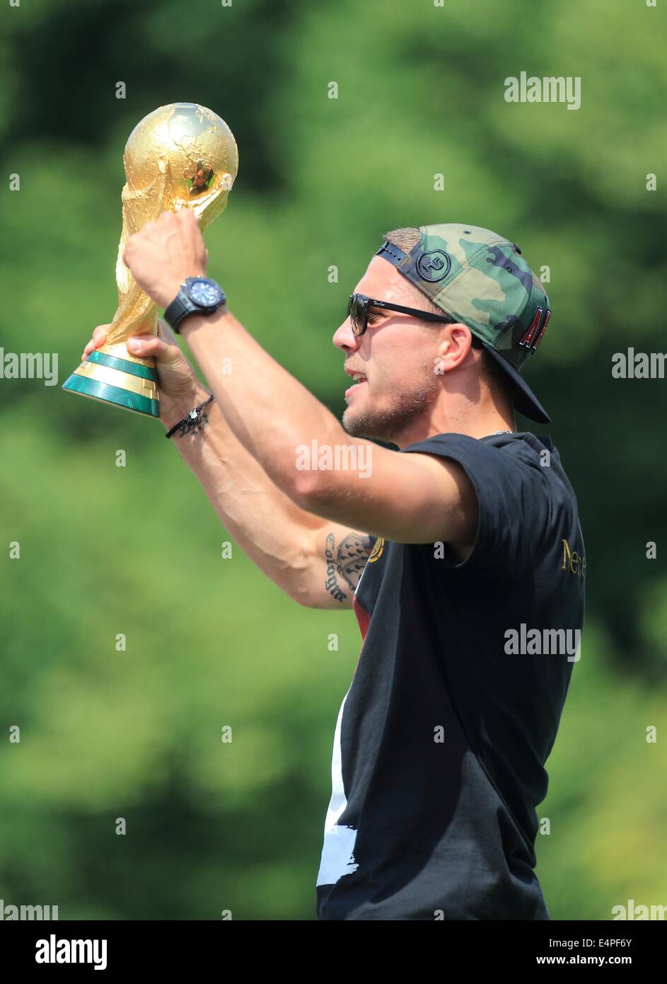 Germany's Lukas Poldolski stands on stage with the World Cup trophy in his hands as he cheers and celebrates during the welcome reception for Germany's national soccer team in front of the Brandenburg Gate, Berlin, Germany, 15 July 2014. The German team won the Brazil 2014 FIFA Soccer World Cup final against Argentina by 1-0 on 13 July 2014, winning the world cup title for the fourth time after 1954, 1974 and 1990. Photo: Jens Wolf/dpa Stock Photo