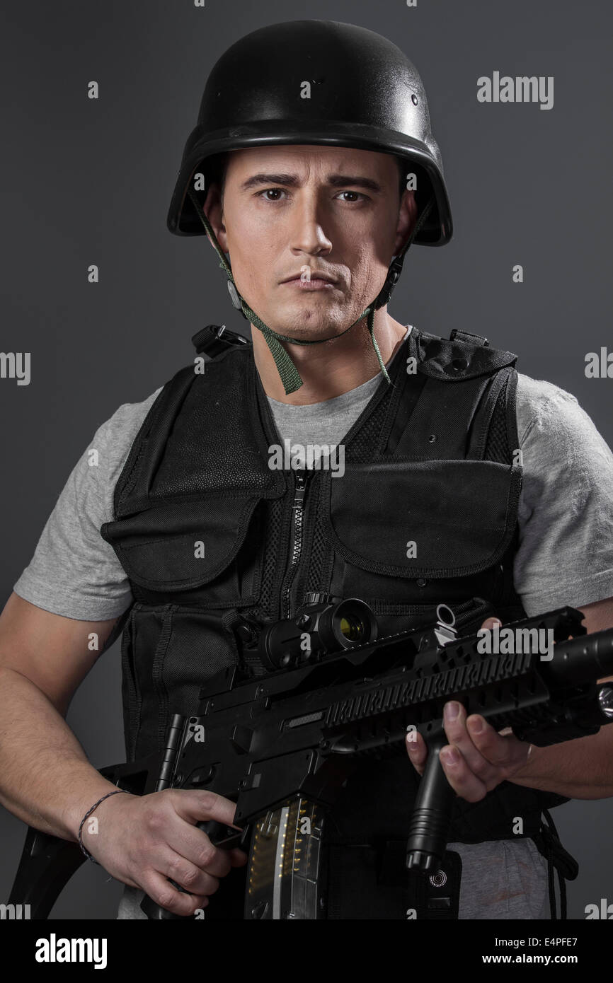 paintball sport player wearing protective helmet aiming pistol ,black