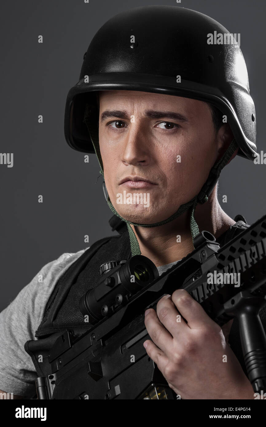 paintball sport player wearing protective helmet aiming pistol ,black