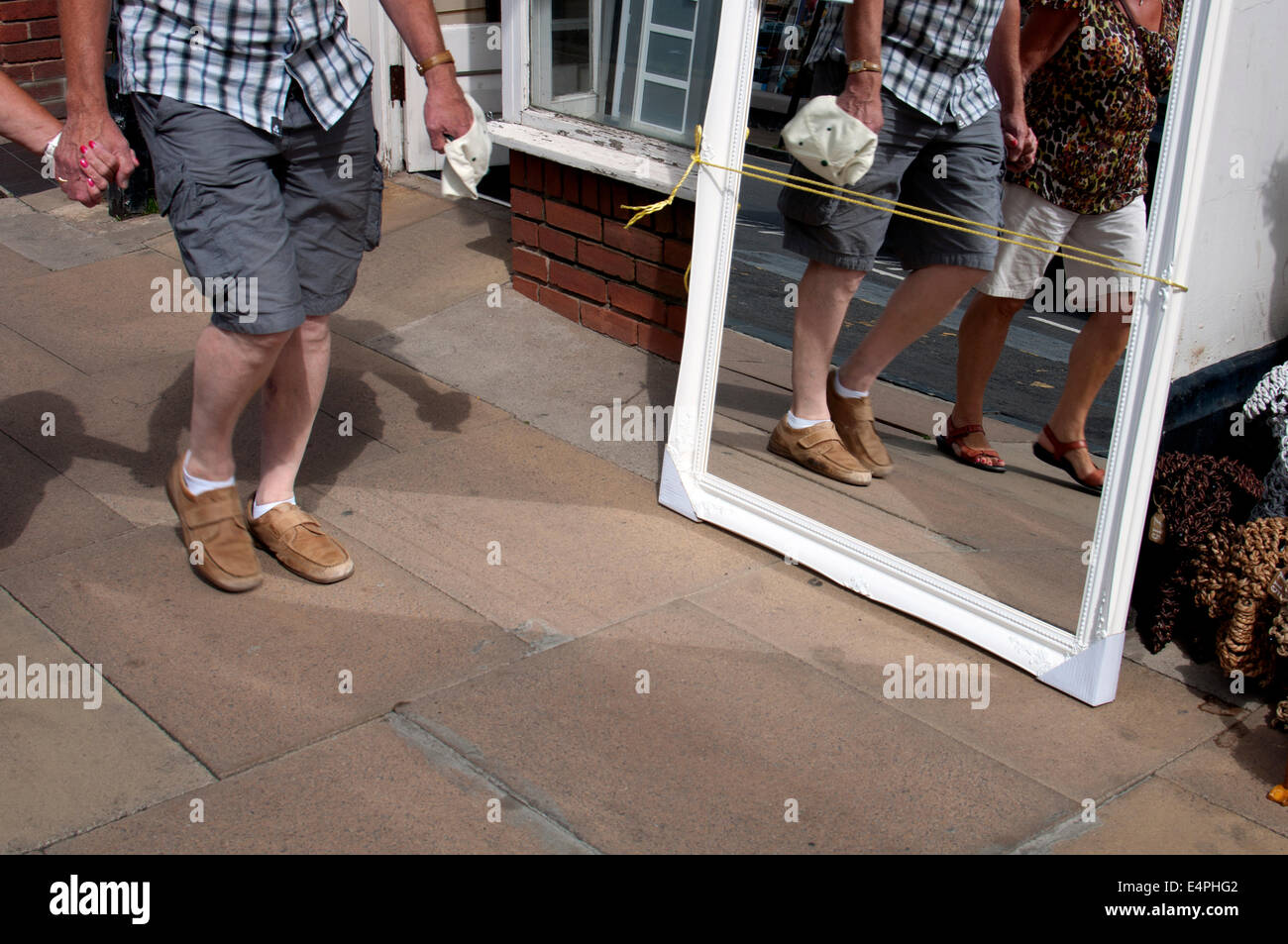 Couple walking hand-in-hand, reflected in a mirror Stock Photo