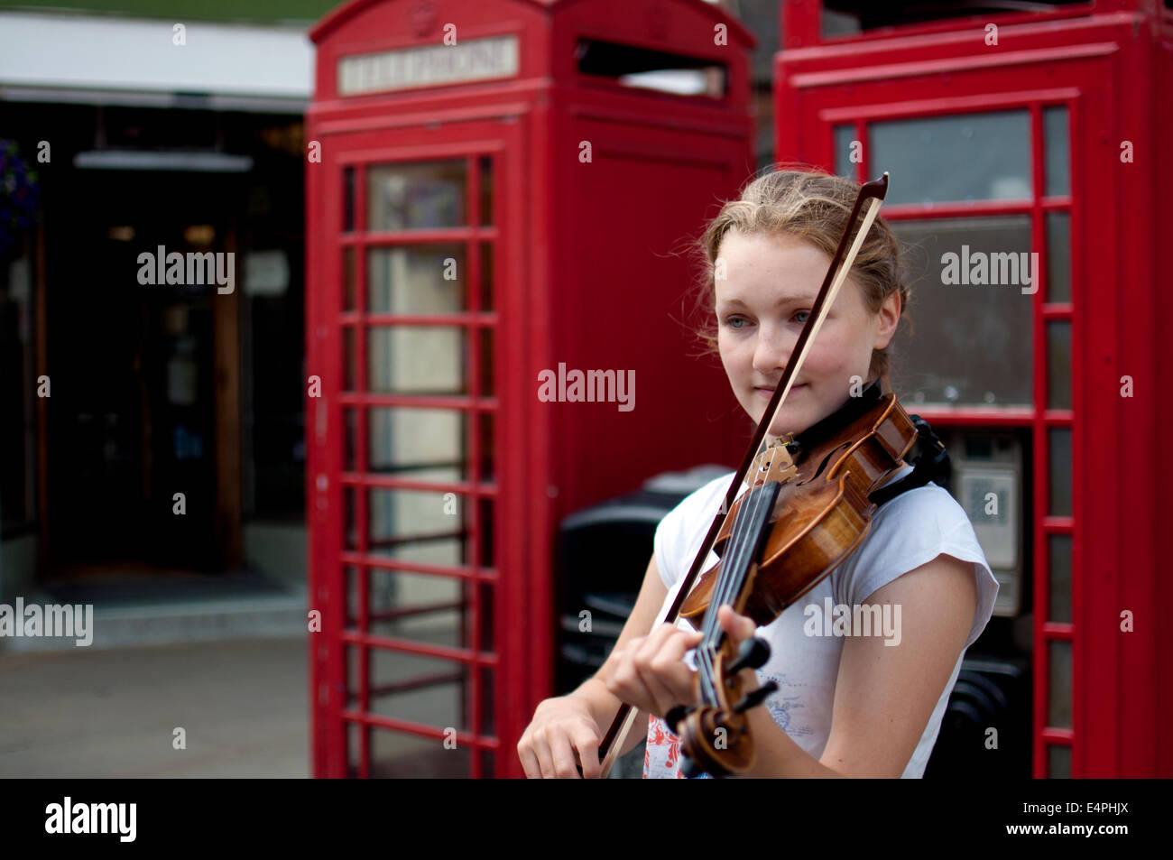 Girl busking with a violin Stock Photo