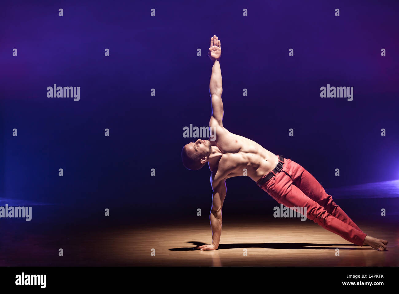 Performance Poses Young and muscular man performing a contemporary dance pose on a stage ...