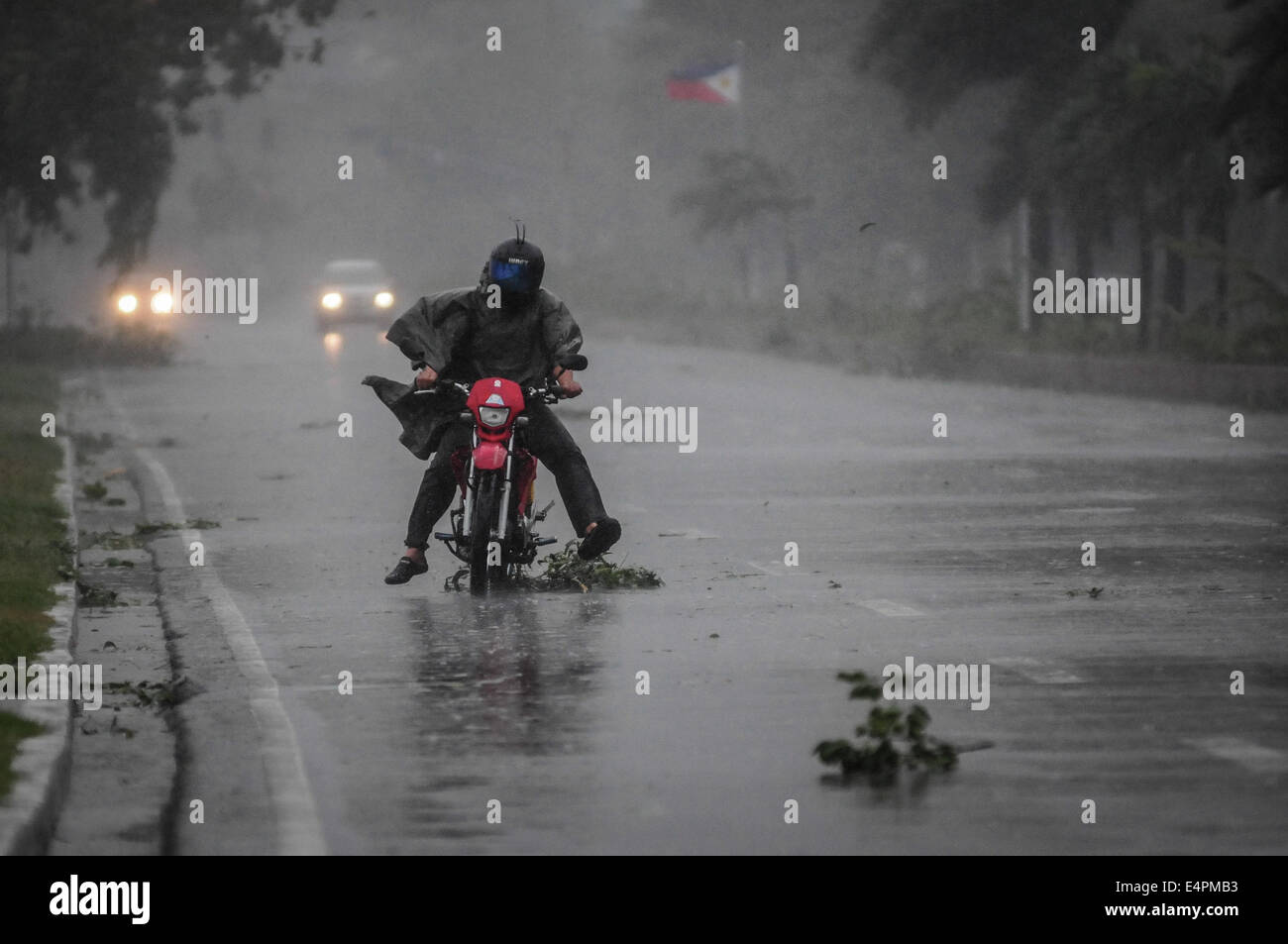 Manila, Philippines. 16th July, 2014. A motorist brave strong winds and rain as he travels along a highway as Typhoon Rammasun barrels across Manila on July 16, 2014. Typhoon Rammasun shut down the Philippine capital on July 16 as authorities said the first major storm of the country's brutal rainy season claimed at least four lives and forced hundreds of thousands to evacuate. Credit:  George Calvelo/NurPhoto/ZUMA Wire/Alamy Live News Stock Photo