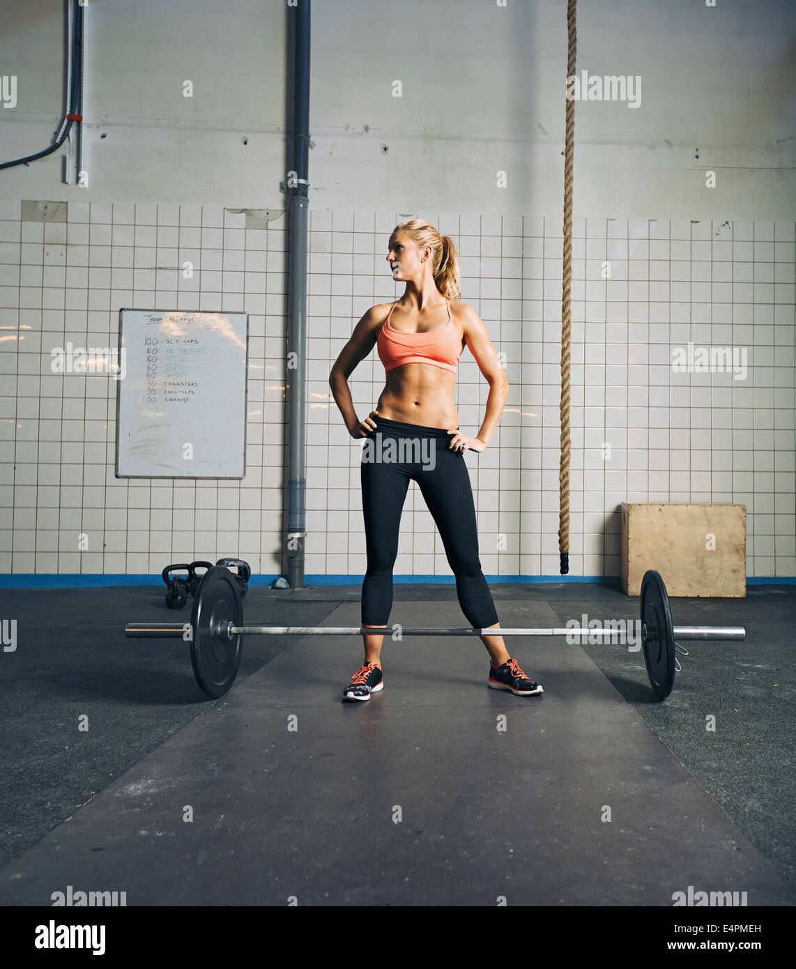 Fit young woman standing at gym with barbell on floor. Strong and muscular crossfit female at gym Stock Photo Alamy