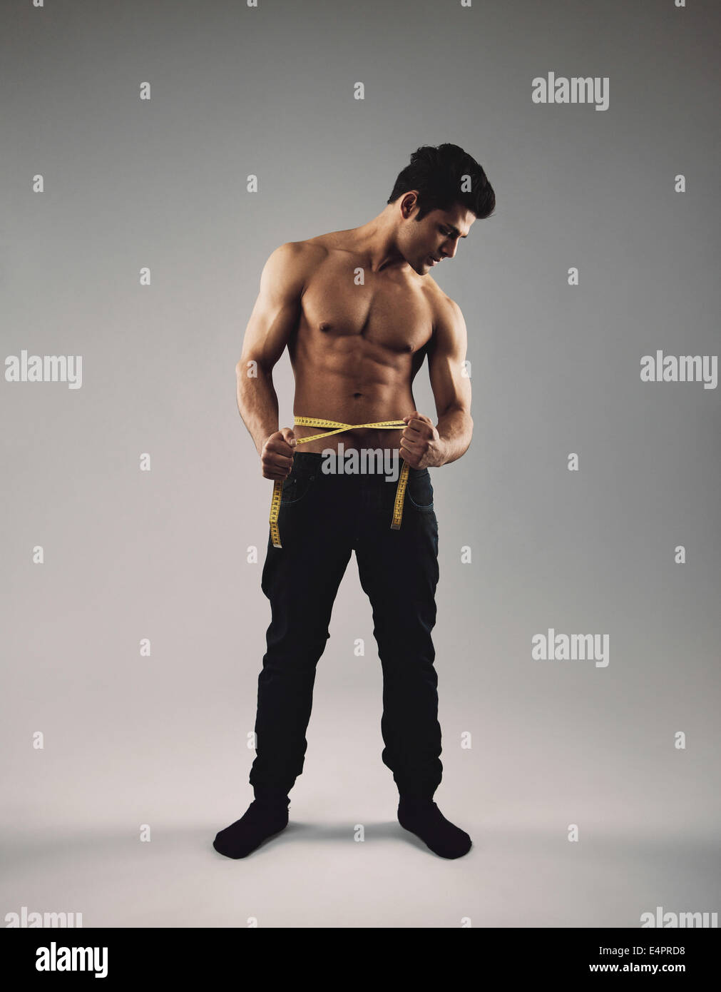 Image of muscular man measure his waist with measuring tape in centimeters  Stock Photo - Alamy