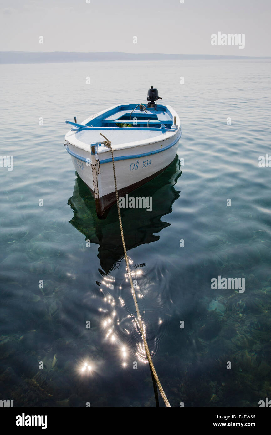 Small boat moored on coast of Croatia Stock Photo