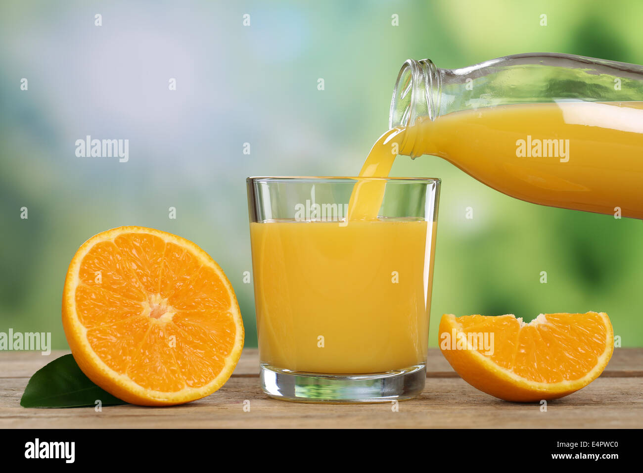 Fresh orange juice pouring into a glass in summer Stock Photo