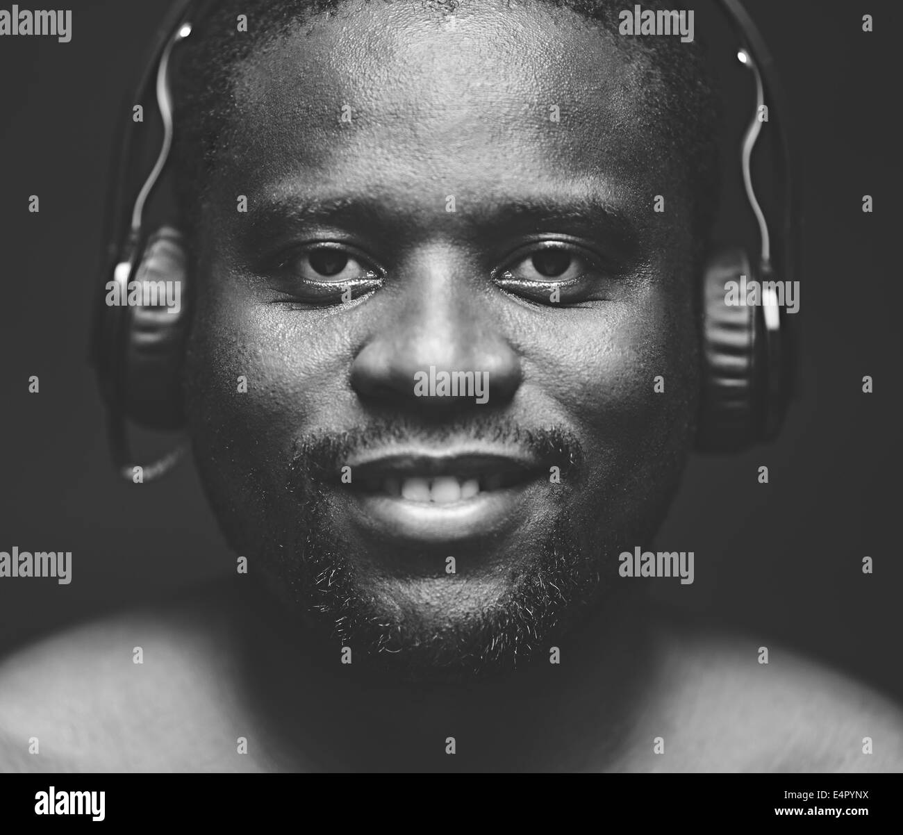 AfricanAmerican guy with headphones looking at camera while listening