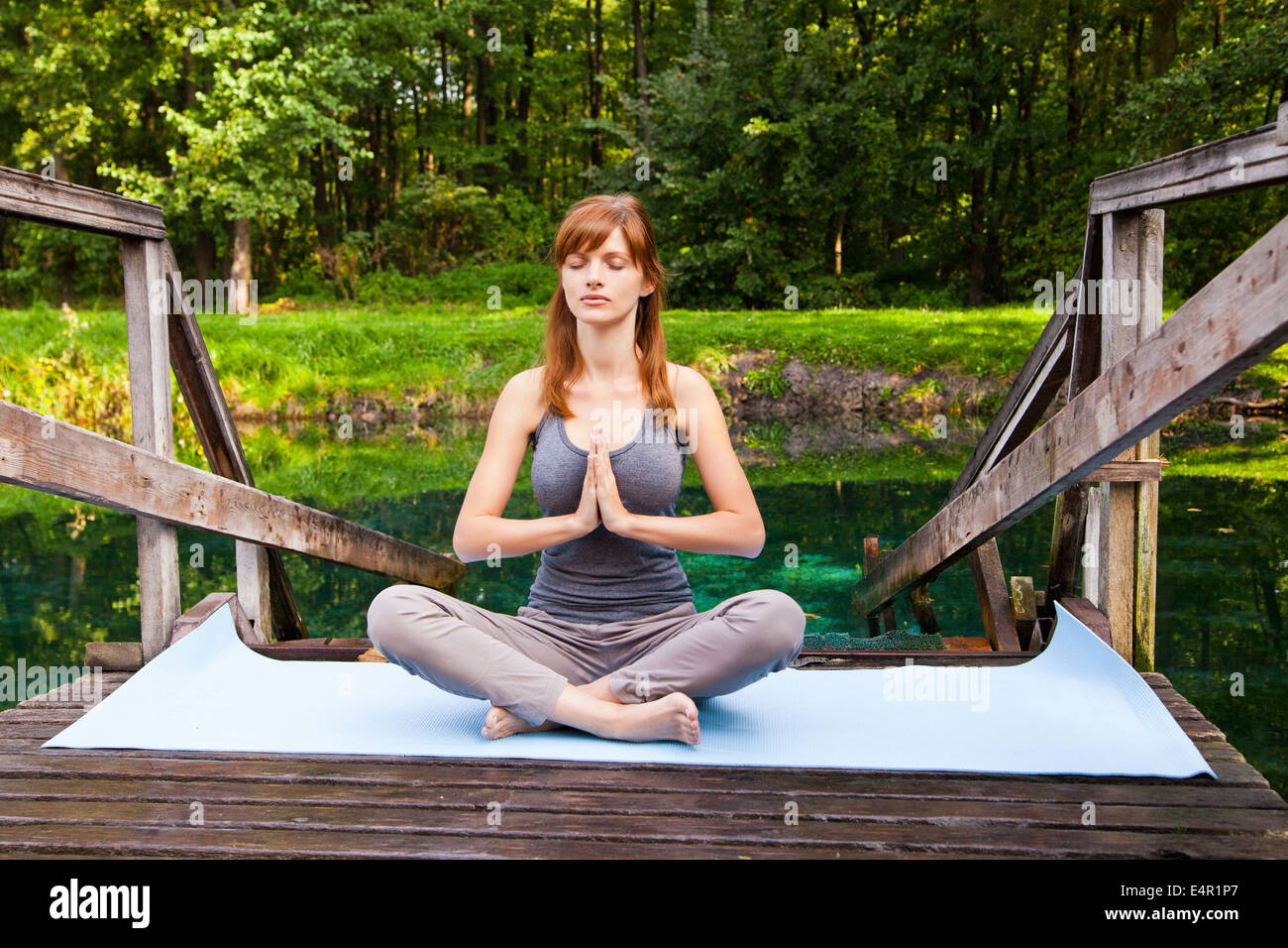 Young girl doing yoga lotus pose in the park Stock Photo - Alamy