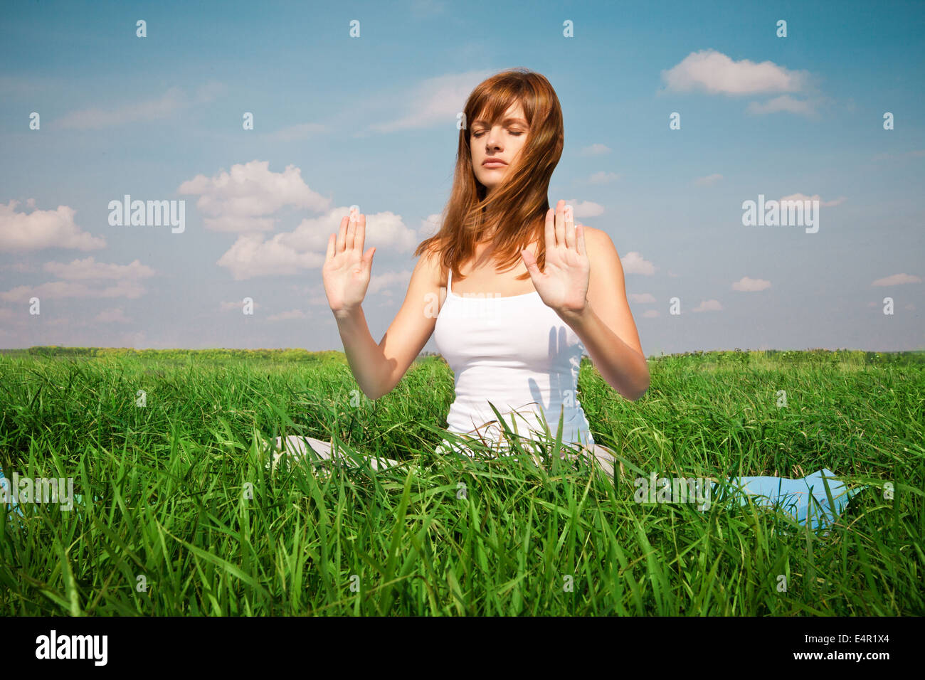 Young girl doing yoga lotus pose in the park Stock Photo - Alamy