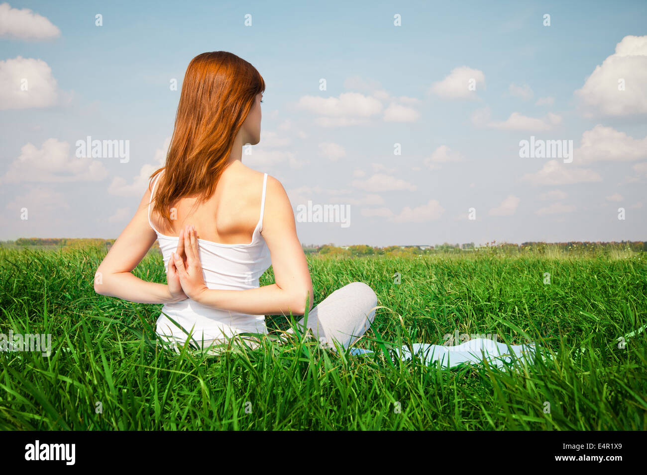 Young girl doing yoga lotus pose in the park Stock Photo - Alamy