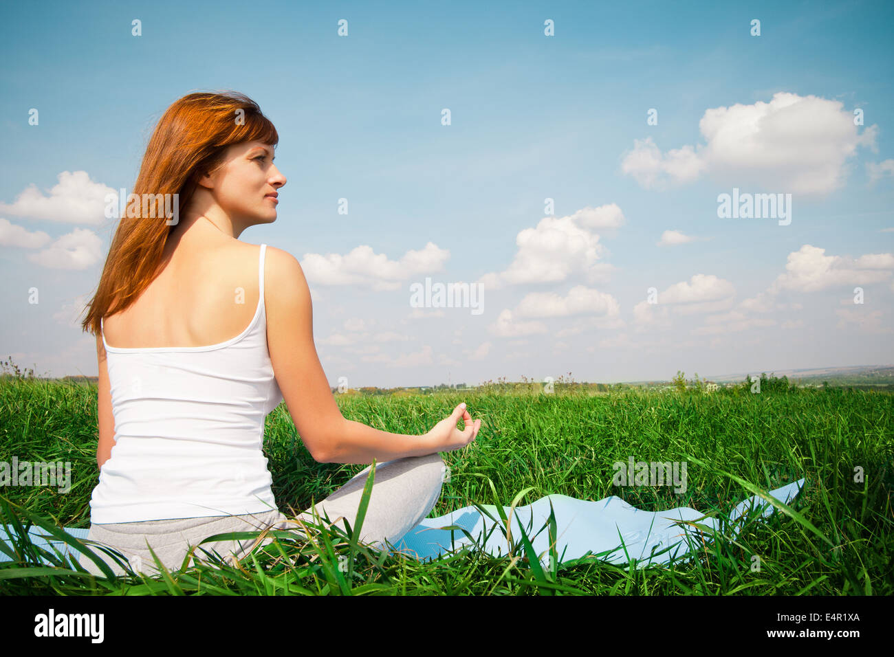Young girl doing yoga lotus pose in the park Stock Photo - Alamy