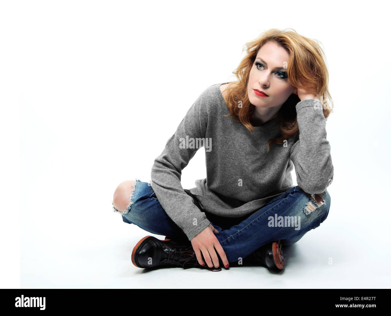 Thinking woman sitting on floor isolated on white background. Stock Photo