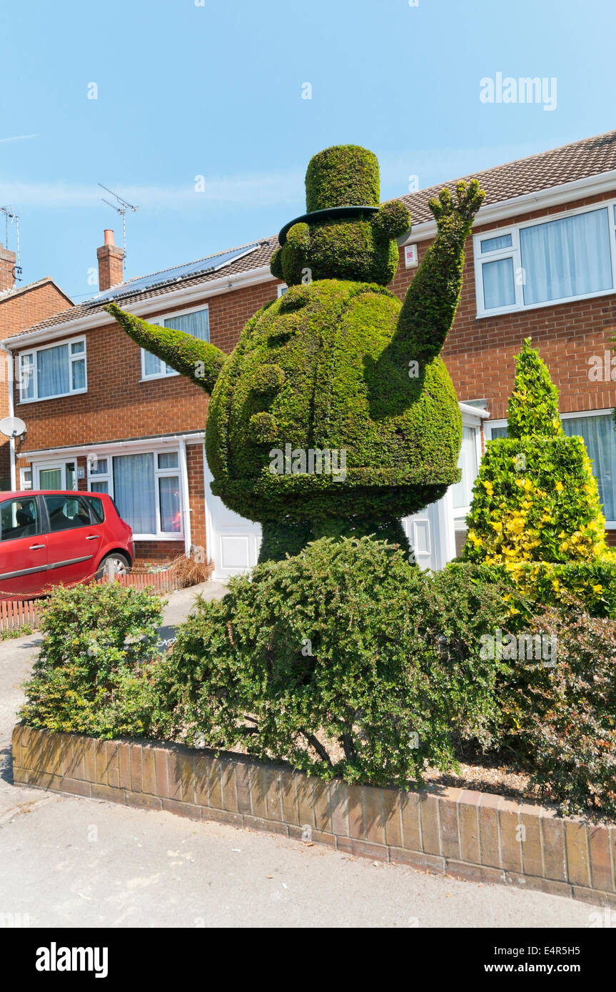 Topiary work of a large fat man in a hat in the front garden of a house in Broadstairs. Stock Photo