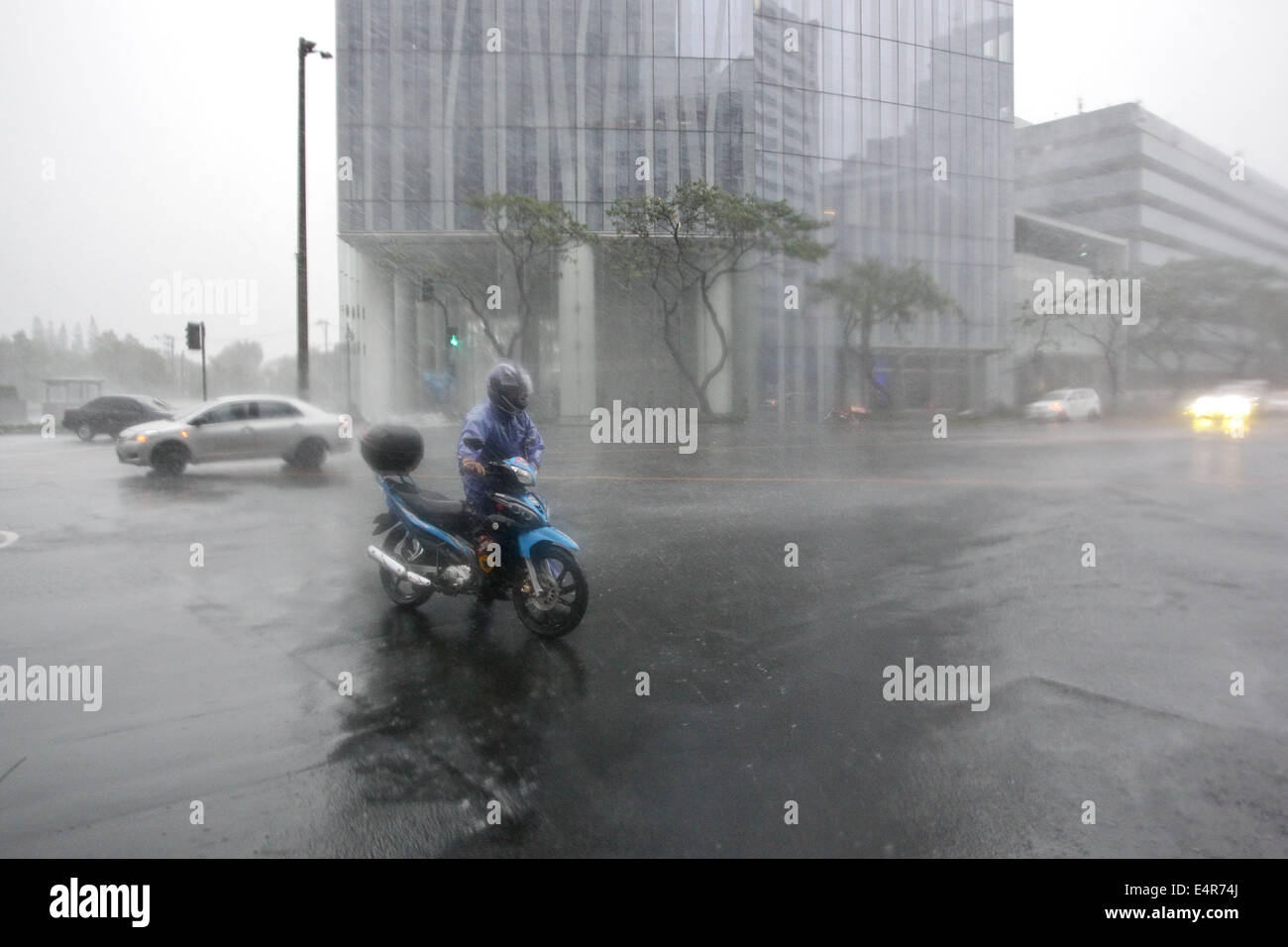 Manila, Philippines. 16th July, 2014. A man attempts to gain control of his motorcycle as Typhoon Rammasun hit Metro Manila. Typhoon Rammasun (locally known as Glenda) had maximum sustained winds of 150 kph and gustiness of up to 185 kph when it hit Metro Manila. Across the country, about 400,000 people had fled their homes and sheltered in evacuation centers, according to the disaster management council. © PACIFIC PRESS/Alamy Live News Stock Photo