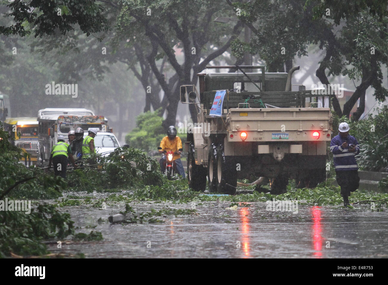 Manila, Philippines. 16th July, 2014. Rescue workers from the local government remove debris from the road as Typhoon Rammasun hit Metro Manila. Typhoon Rammasun (locally known as Glenda) had maximum sustained winds of 150 kph and gustiness of up to 185 kph when it hit Metro Manila. Across the country, about 400,000 people had fled their homes and sheltered in evacuation centers, according to the disaster management council. © PACIFIC PRESS/Alamy Live News Stock Photo