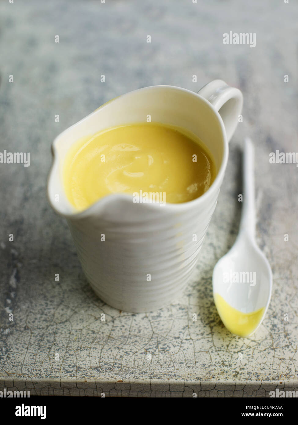 Small jug containing hollandaise sauce Stock Photo Alamy