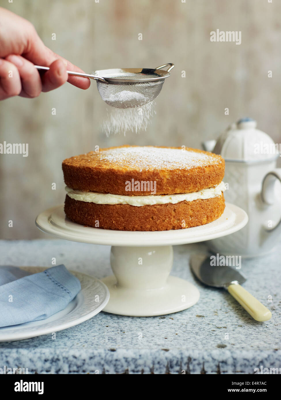Dusting Victoria sponge cake with icing sugar Stock Photo Alamy