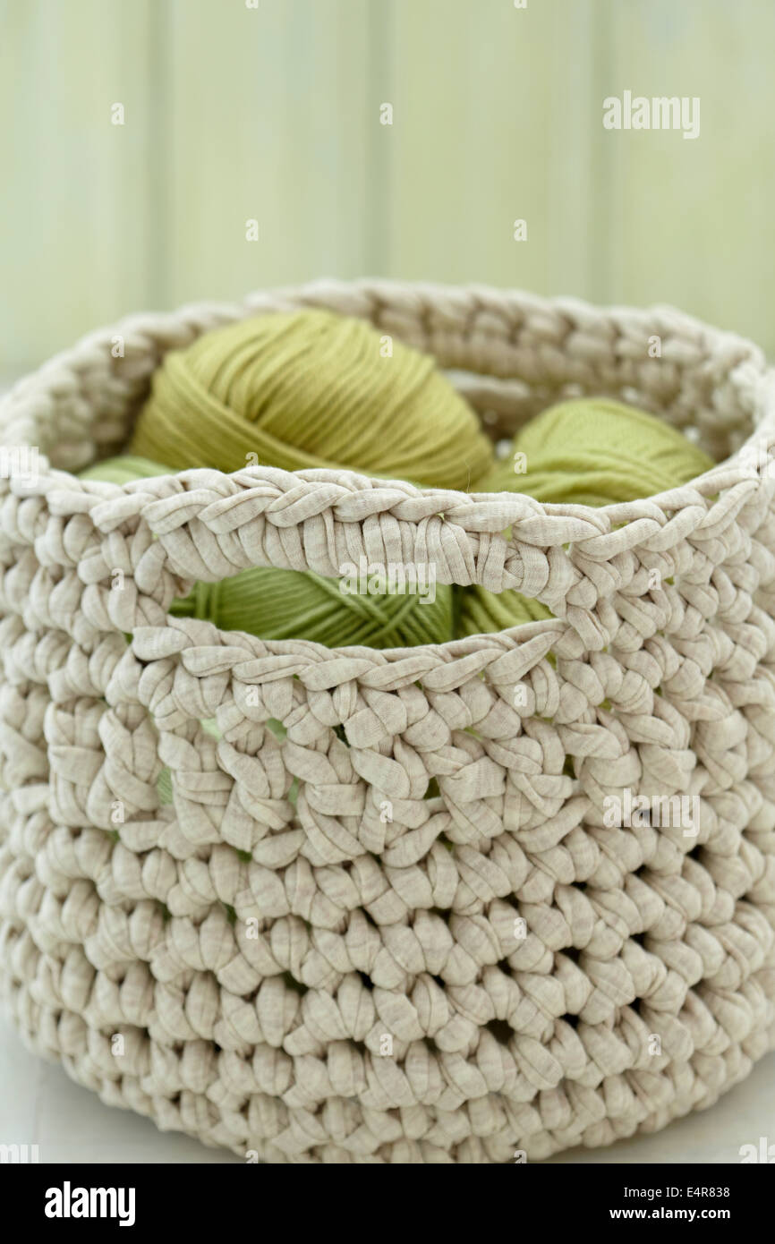 Crocheted structured basket filled with balls of wool Stock Photo