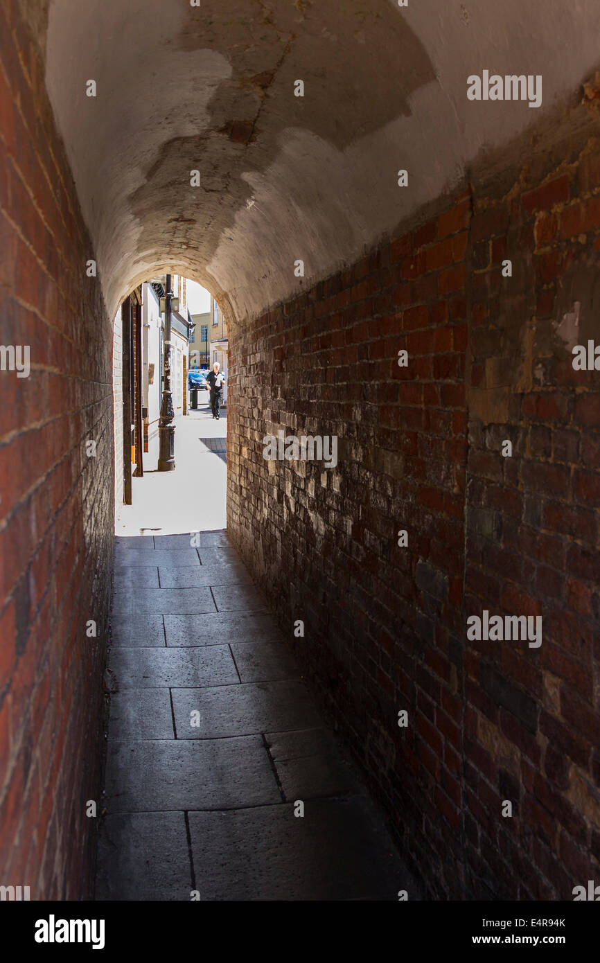 Brick Alleyway between two buildings with arched ceiling, Rugby. Stock Photo