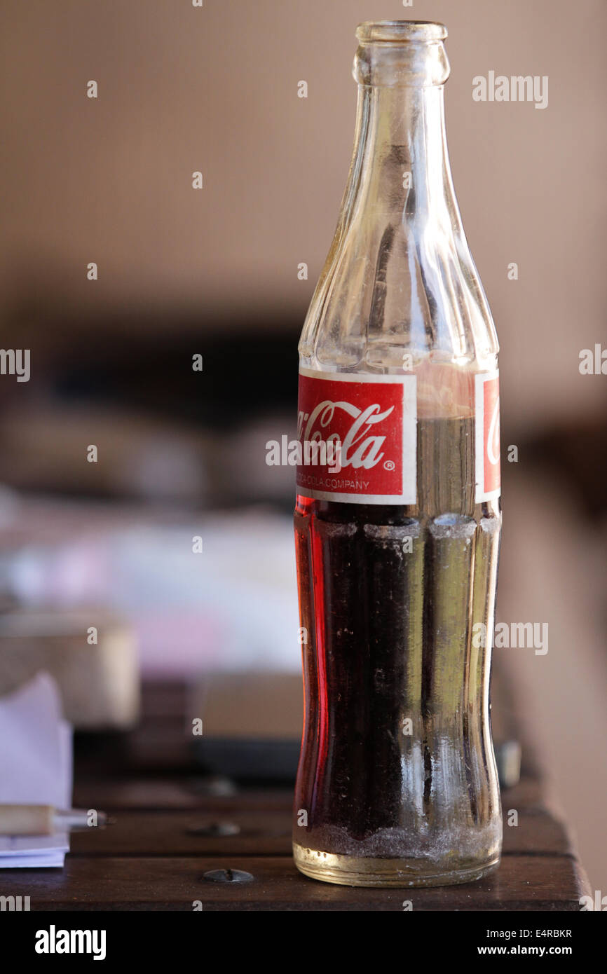 Half full glass coca-cola bottle on a wooden table Stock Photo