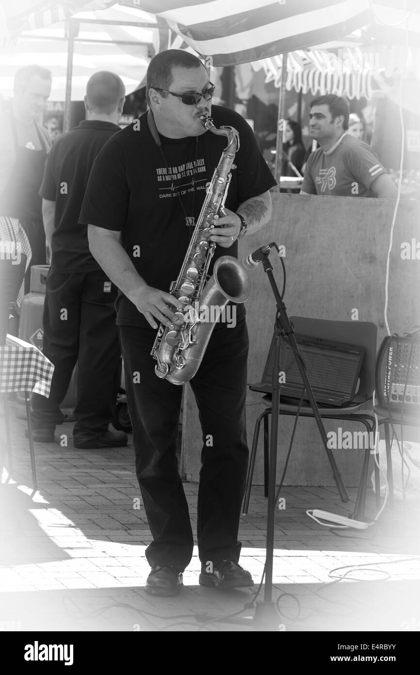 Male Saxophonist playing in Rugby Town Centre on Market Day. Stock Photo