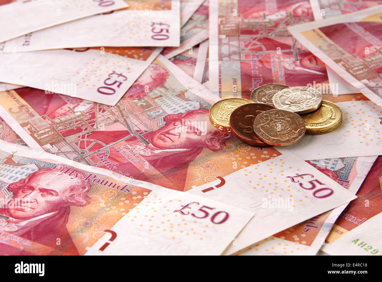 Background of British Fifty Pound Banknotes and a stack of coins Stock Photo