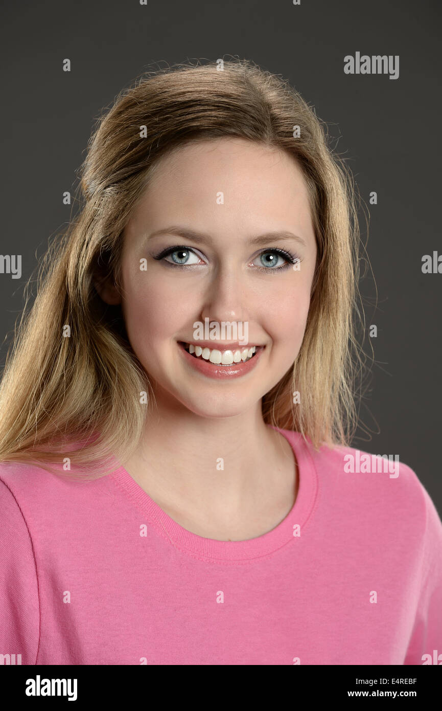 Portrait of young woman smiling over gray background Stock Photo - Alamy