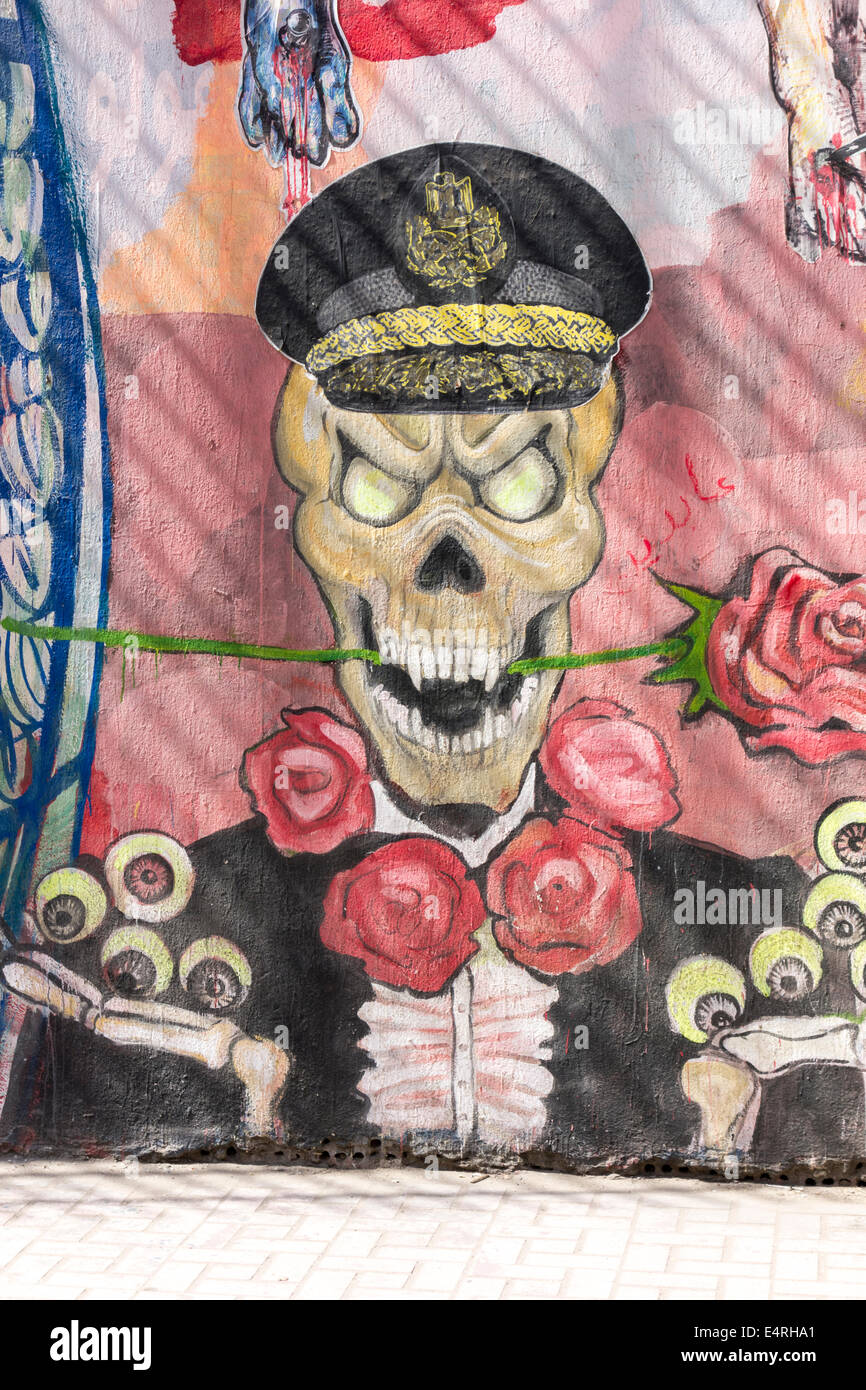 graffiti wall painting of grinning army skeleton eating flower holding eyes, Mohamed Mahmoud street, Cairo, Egypt Stock Photo
