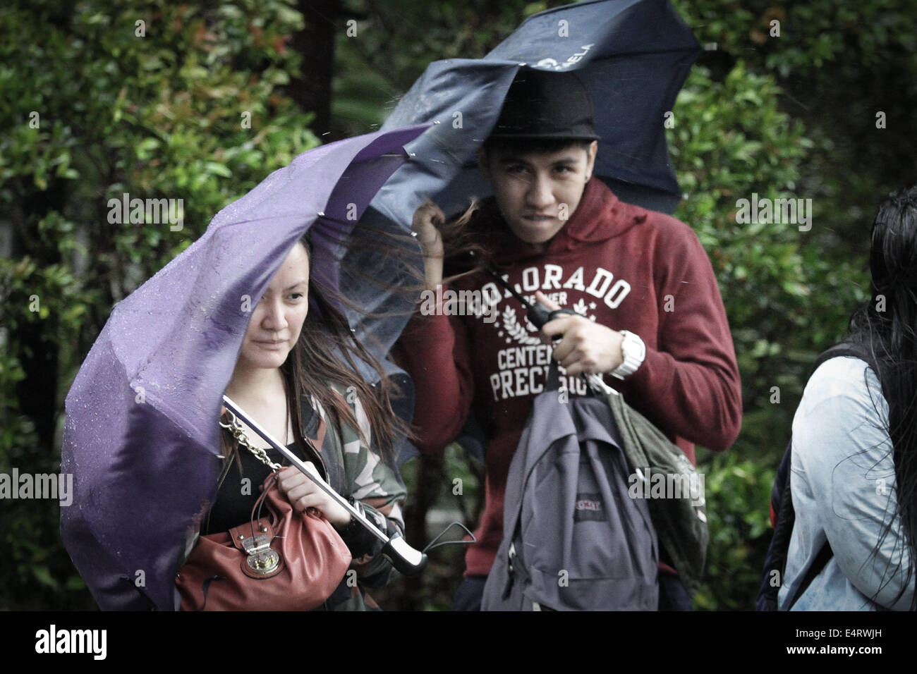 Manila, Philippines. 16th July, 2014. Commuters hold on to their umbrellas as Typhoon Rammasun hit Metro Manila on July 16, 2014. Typhoon Rammasun (locally known as Glenda) had maximum sustained winds of 150 kph and gustiness of up to 185 kph when it hit Metro Manila. Across the country, about 400,000 people had fled their homes and sheltered in evacuation centers, according to the disaster management council. Credit:  ZUMA Press, Inc./Alamy Live News Stock Photo