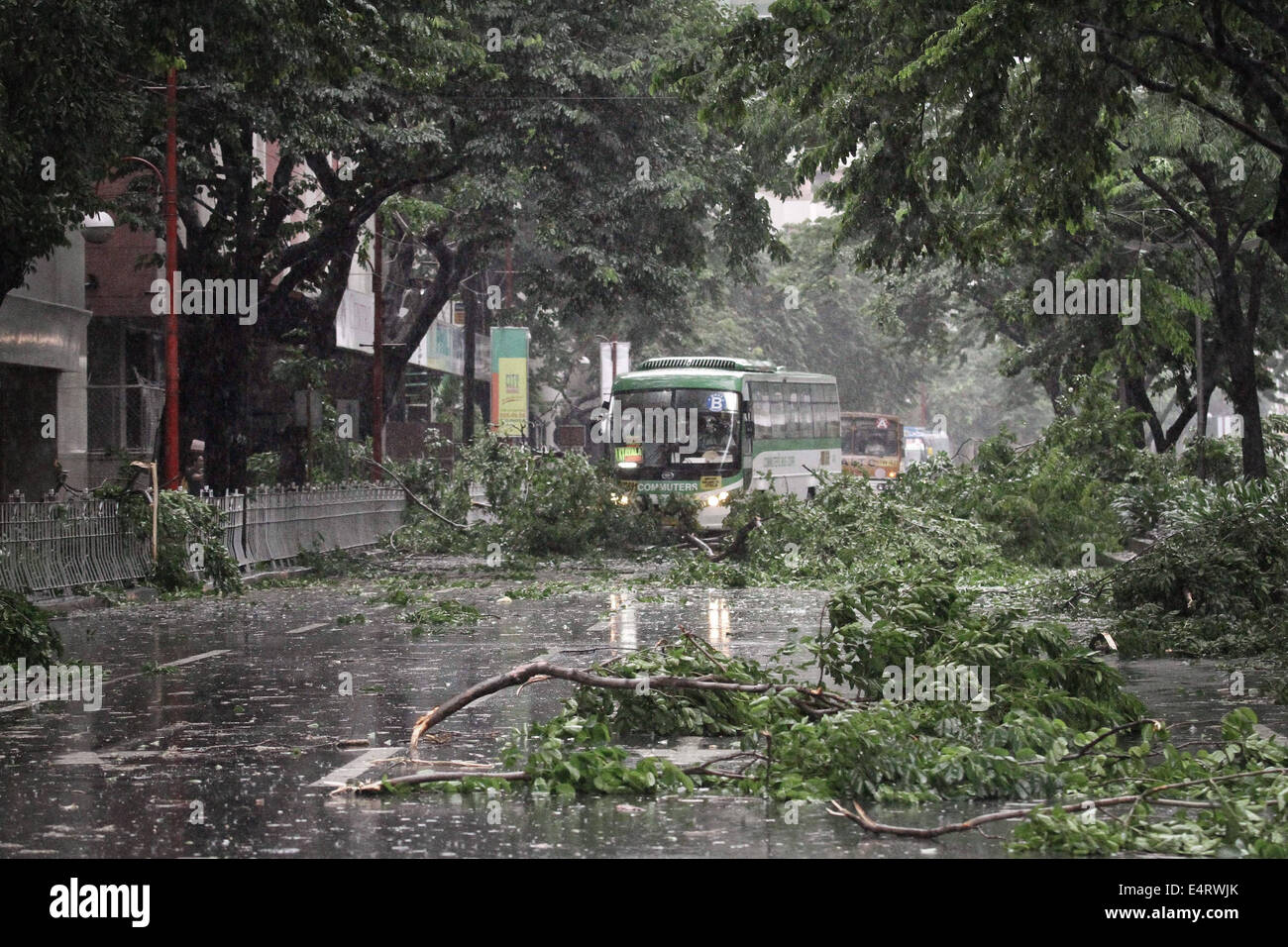 Manila, Philippines. 16th July, 2014. A commuter bus makes its way through debris brought down by Typhoon Rammasun on July 16, 2014. Typhoon Rammasun (locally known as Glenda) had maximum sustained winds of 150 kph and gustiness of up to 185 kph when it hit Metro Manila. Across the country, about 400,000 people had fled their homes and sheltered in evacuation centers, according to the disaster management council. Credit:  ZUMA Press, Inc./Alamy Live News Stock Photo