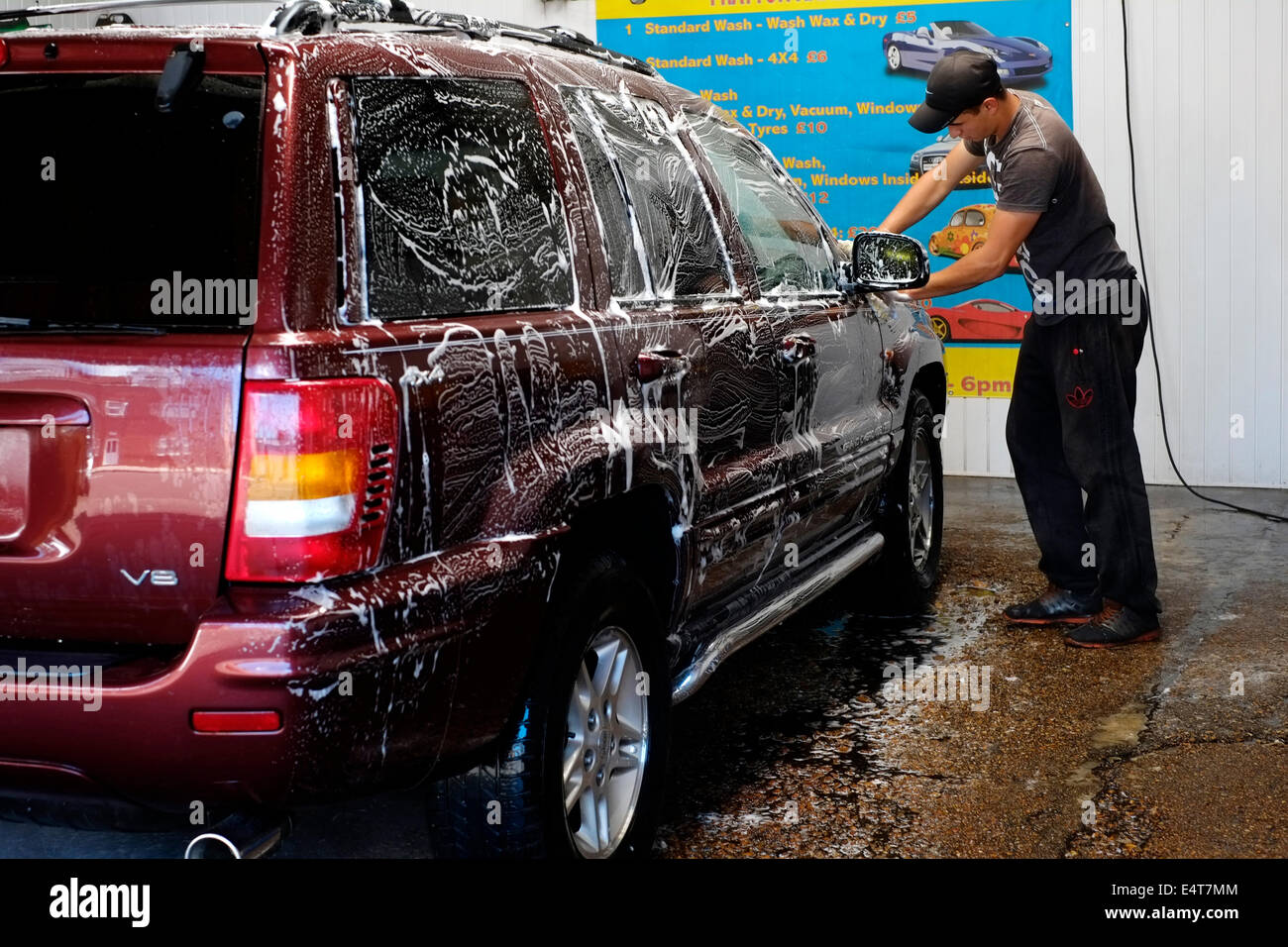 east european immigrants hand washing a car at their car cleaning business england uk Stock Photo