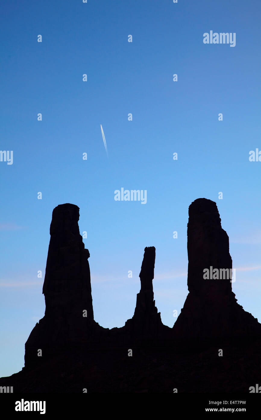 The Three Sisters spires, and jet contrail, Monument Valley, Navajo Nation, Utah/Arizona Border, USA Stock Photo