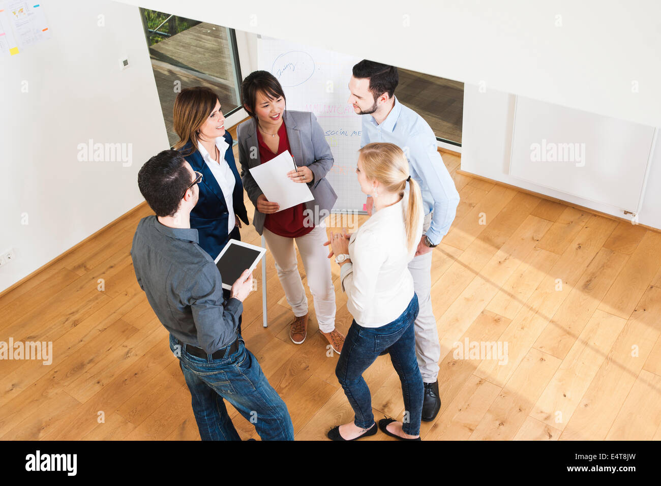 Overhead view of group of young business people and businesswoman in discussion in office, Germany Stock Photo