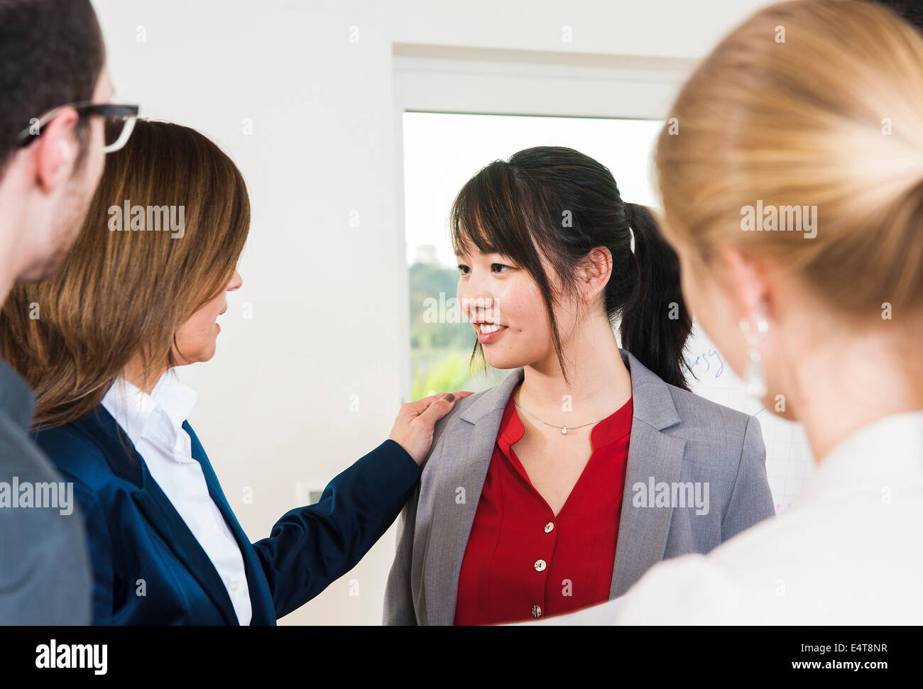 Group of young business people and businesswoman in discussion in office, young business woman being congratulated, Germany Stock Photo