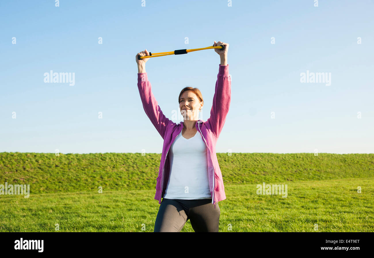 Mature Woman Exercising with Resistance Band Outdoors, Baden-Wurttemberg, Germany Stock Photo