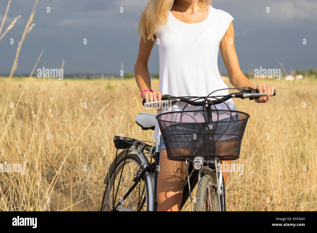 woman girl holding  bicycle countryside field summer sunlight Stock Photo