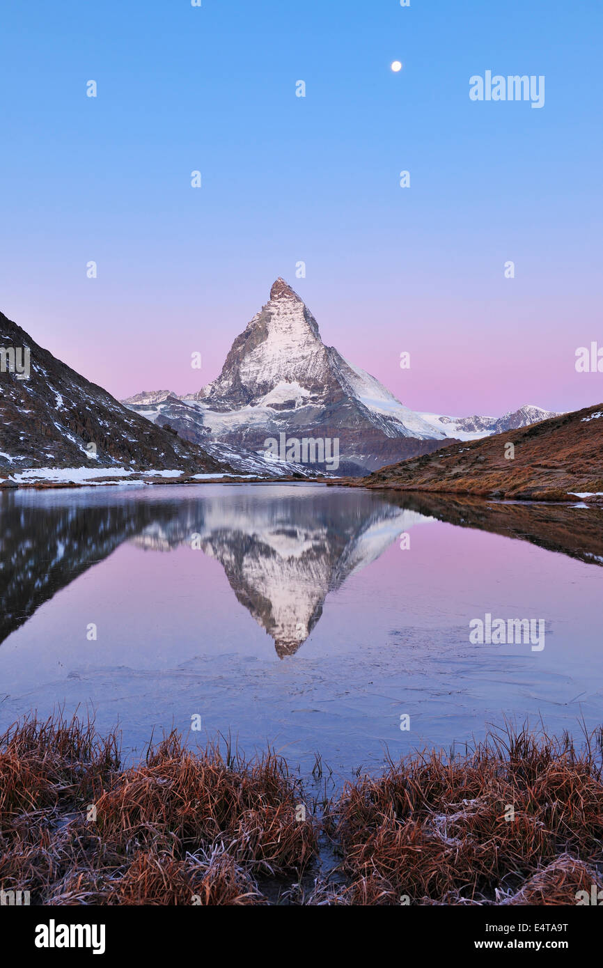 Matterhorn reflected in Lake Riffelsee at Dawn with Moon, Zermatt, Alps, Valais, Switzerland Stock Photo