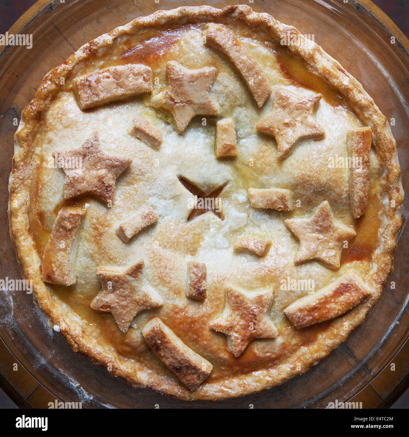 Overhead view of freshly baked apple pie with star shaped cut-outs on top, studio shot Stock Photo