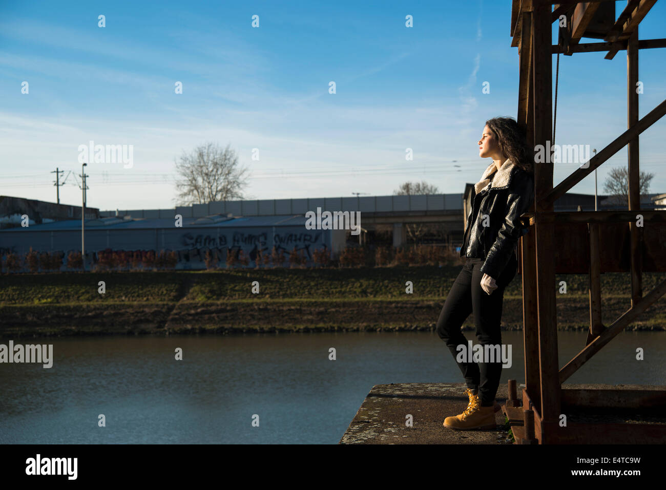 Teenage girl standing on commercial dock outdoors, looking into the distance, Germany Stock Photo