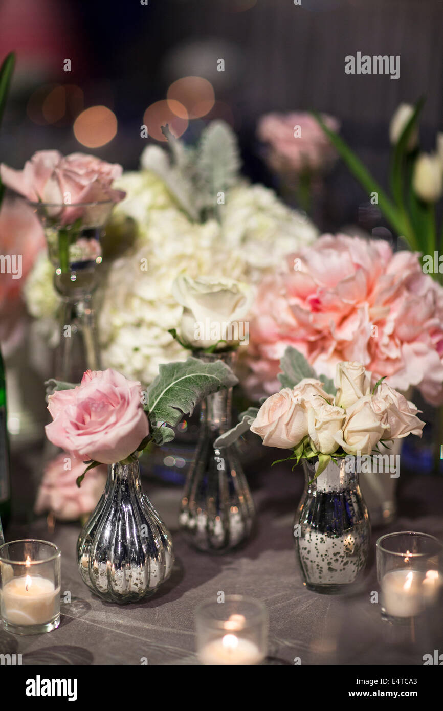 Close-up of vases with roses and peonies on table with candlelit votive  holders at reception, Canada Stock Photo - Alamy