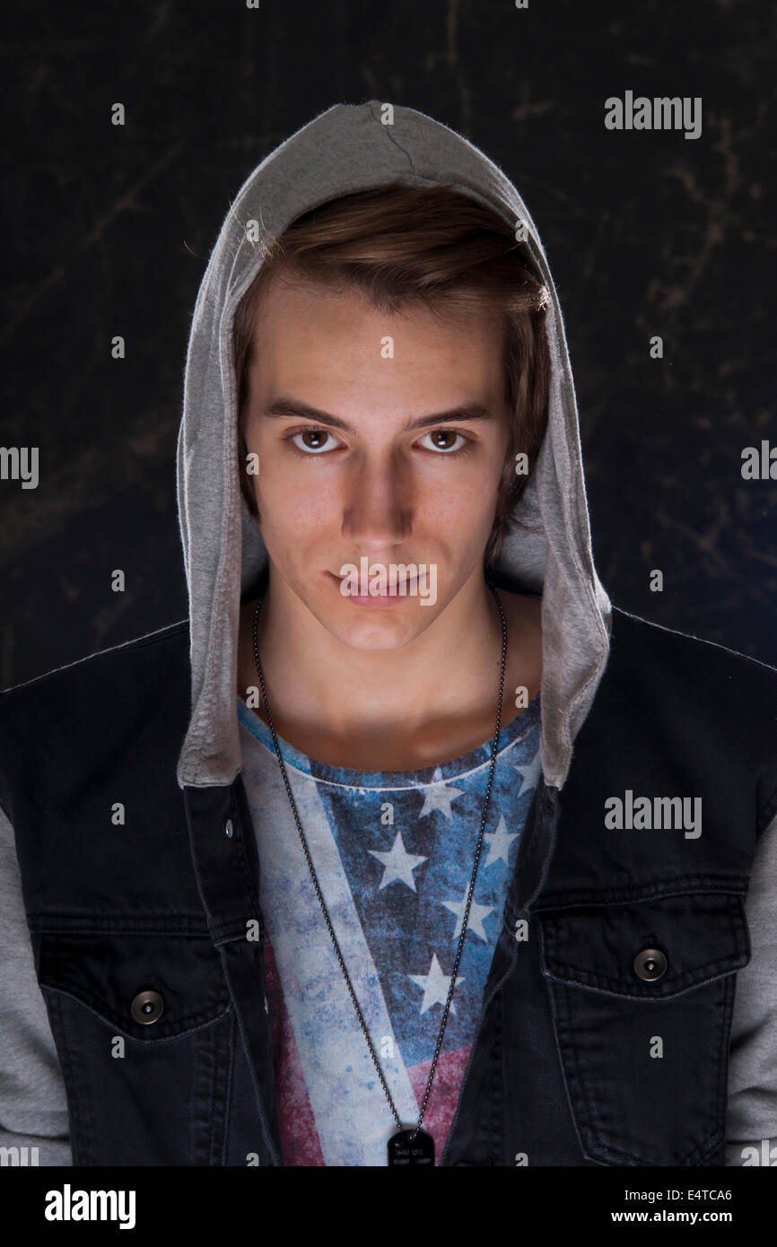 Portrait of teenage boy wearing hoodie and looking at camera, studio shot Stock Photo