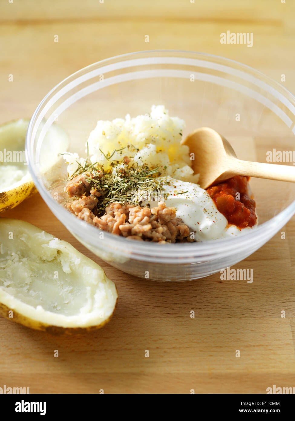 Potato skins and bowl of mixture for making stuffed baked potatoes with