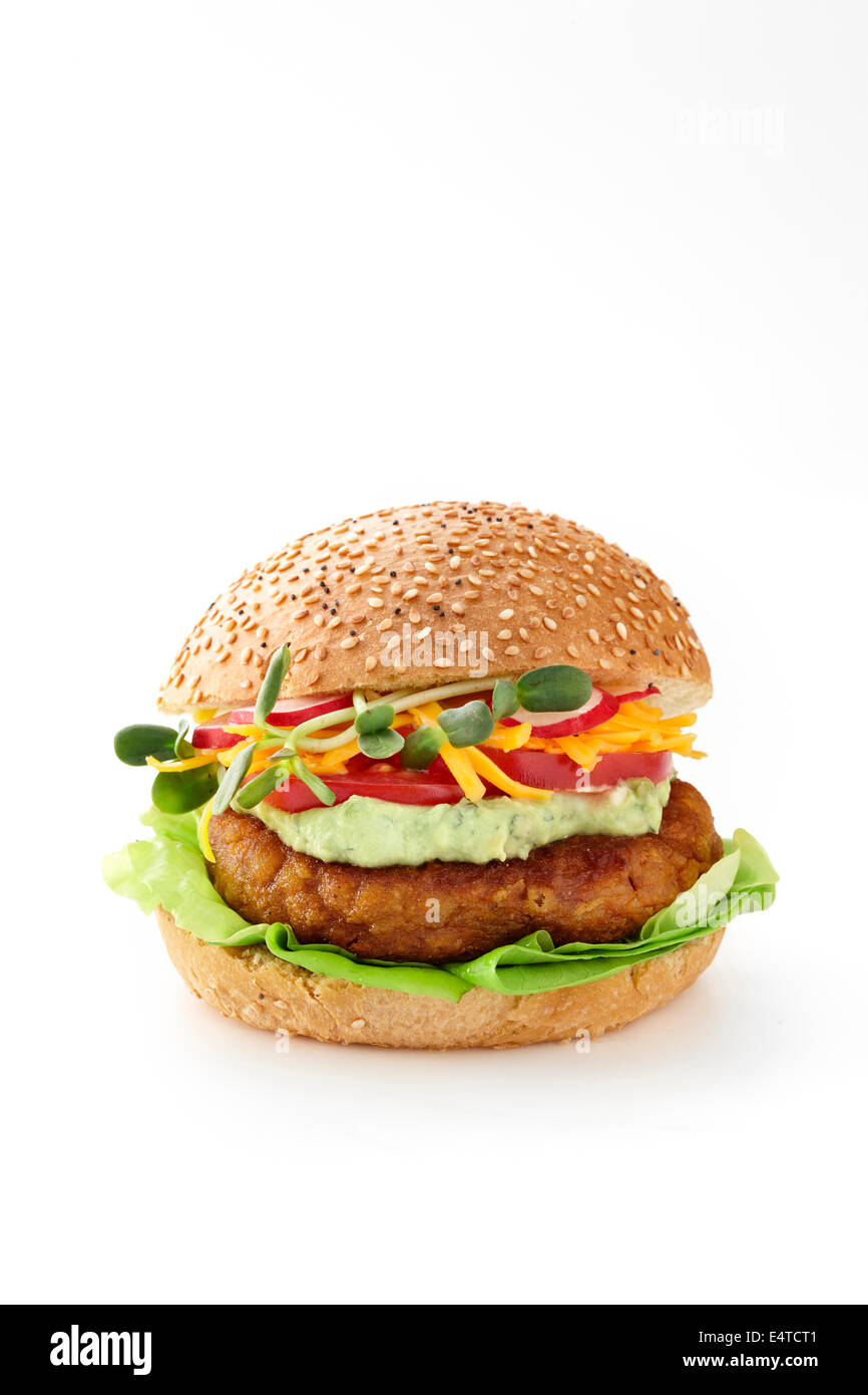 Chickpea burger on sesame bun with lettuce, guacamole, shredded cheddar cheese, tomatoes, and sprouts, on white background Stock Photo