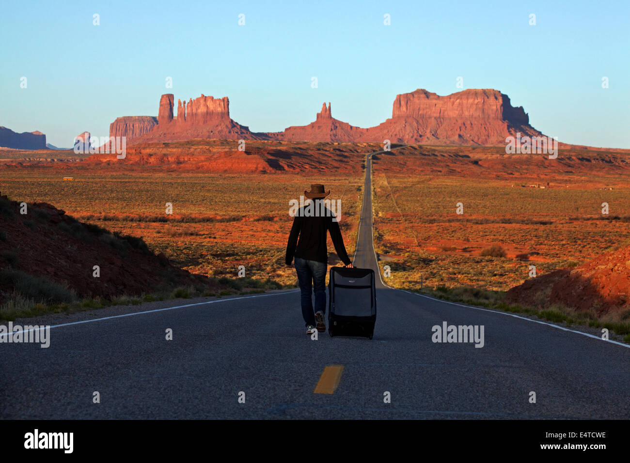 Woman with suitcase on U.S. Route 163 heading towards Monument Valley, Navajo Nation, Utah, near Arizona Border, USA Stock Photo