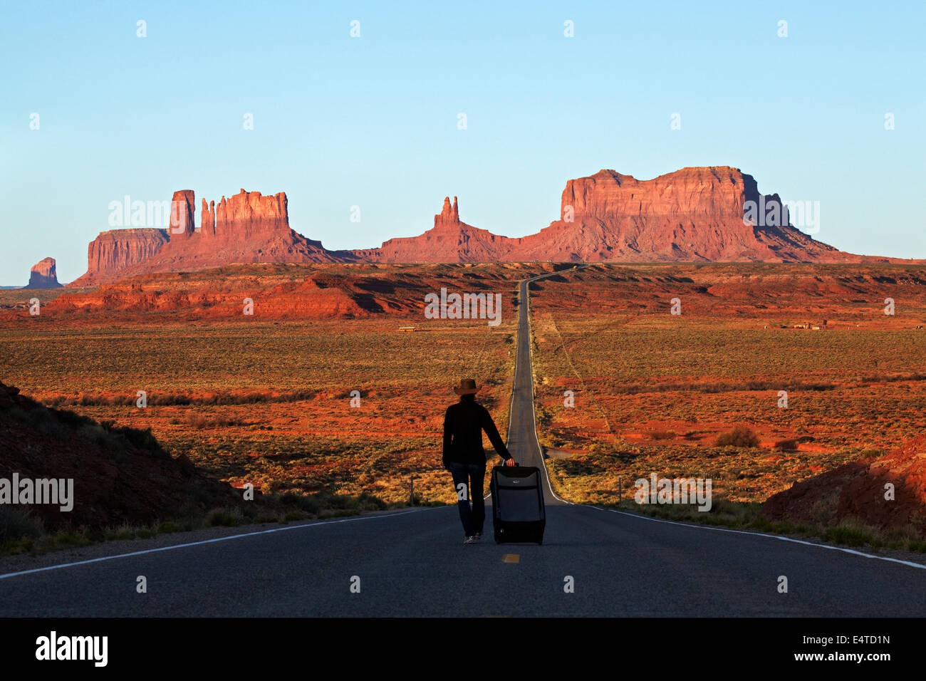 Woman with suitcase on U.S. Route 163 heading towards Monument Valley, Navajo Nation, Utah, near Arizona Border, USA Stock Photo